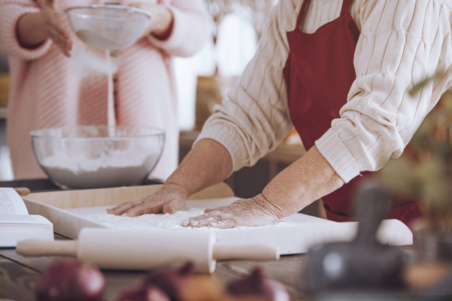 Close-up of person making cake on wooden board on countertop with rolling pin