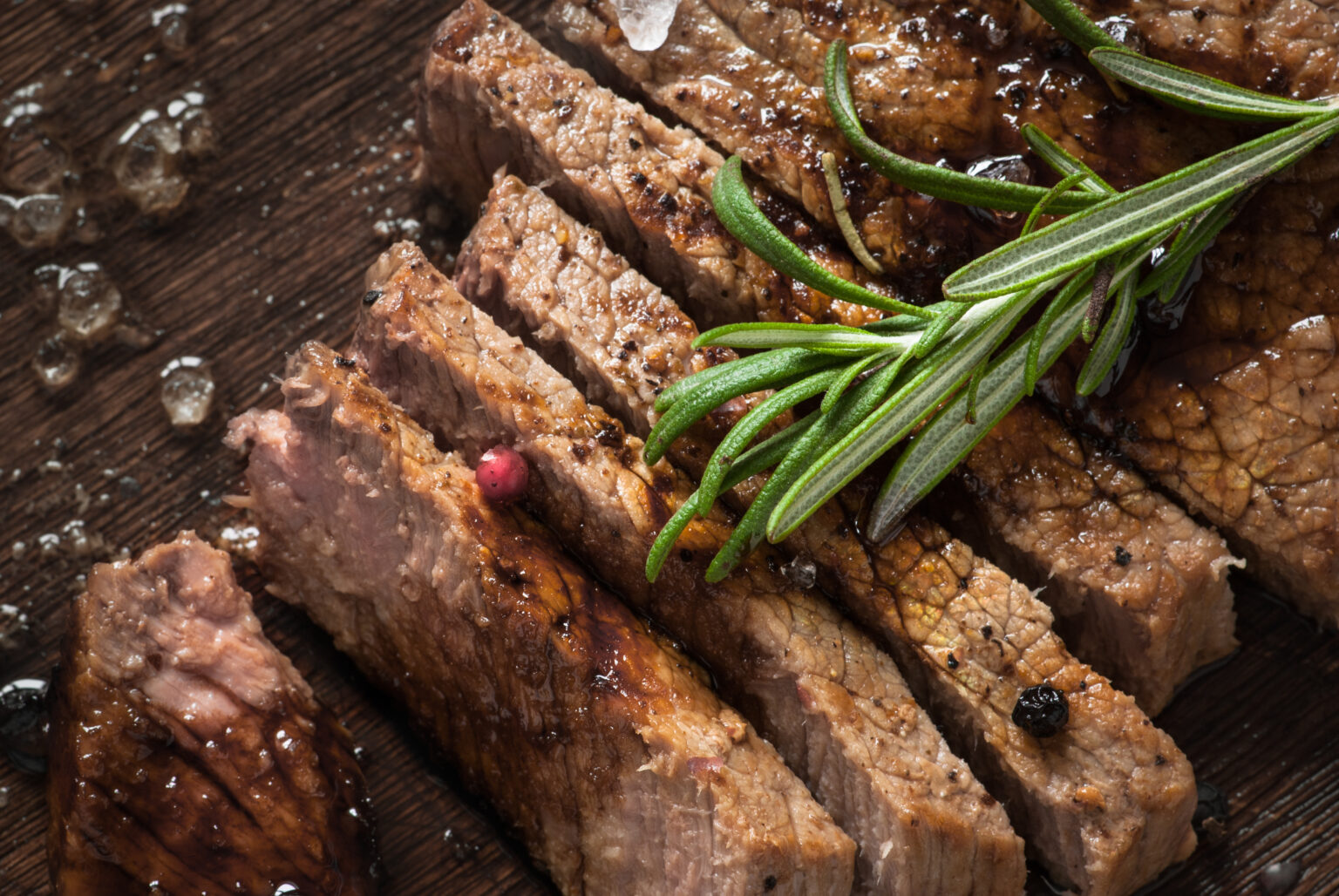 Sliced meat. Grilled beef steak on wooden cutting board. Top view.