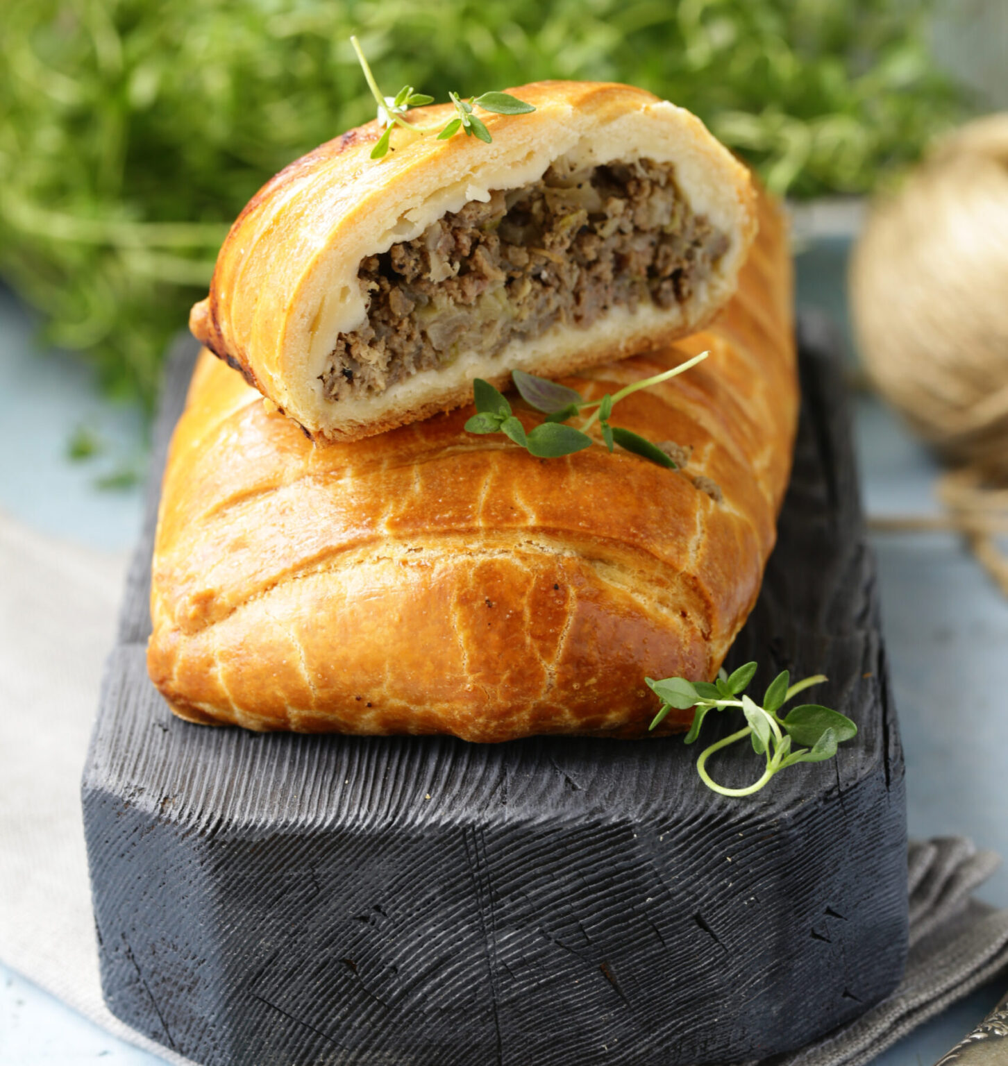 puff pastry pie with meat on a wooden board