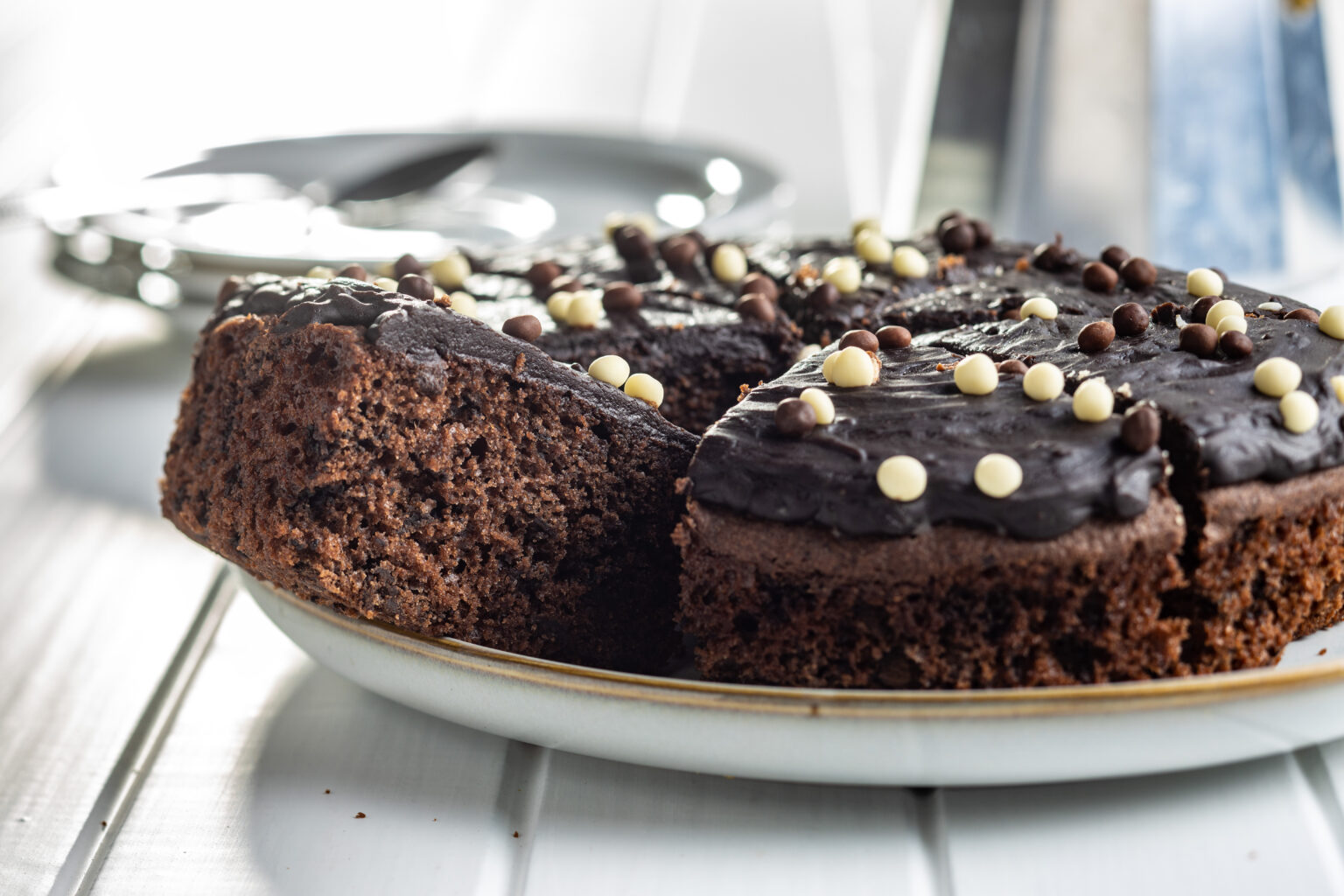 Sweet chocolate cake on plate on white table.